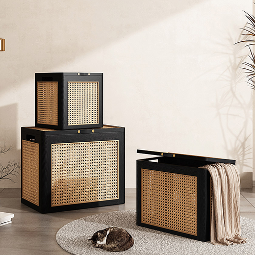 Set of three woven storage baskets with black frames in a room setting.